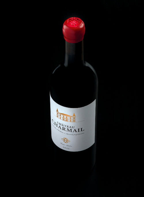 Wine bottle with a red cap on a black background
